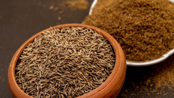 Whole and ground cumin in bowls